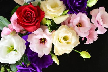 rose and eustoma flowers close up on black background 