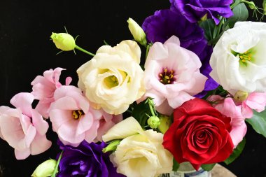 rose and eustoma flowers close up on black background 