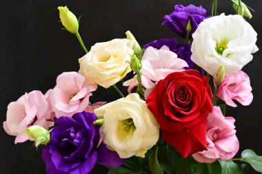rose and eustoma flowers close up on black background 