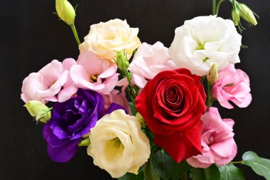 rose and eustoma flowers close up on black background 