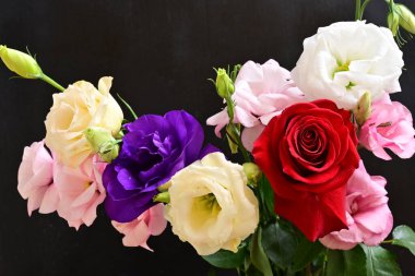 rose and eustoma flowers close up on black background 