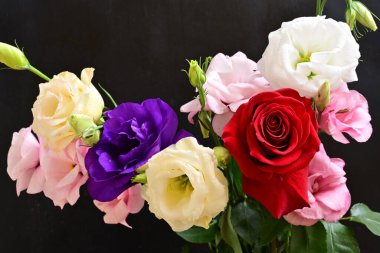 rose and eustoma flowers close up on black background 