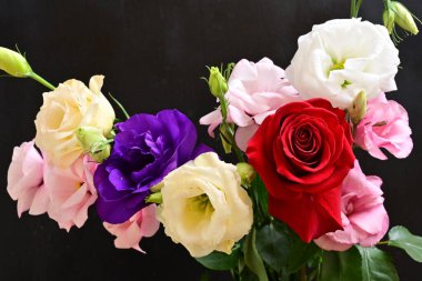 rose and eustoma flowers close up on black background 