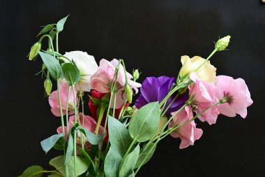 rose and eustoma flowers close up on black background 