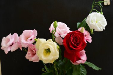rose and eustoma flowers close up on black background 
