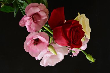 rose and eustoma flowers close up on black background 