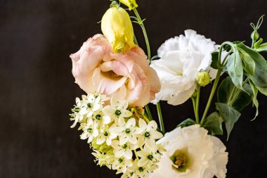 Siyah arka planda narin çiçekleri olan güzel çiçek buketini kapat.         