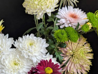 Beyaz pembe ve yeşil de dahil olmak üzere renkli çiçeklerin düzenlenmesi