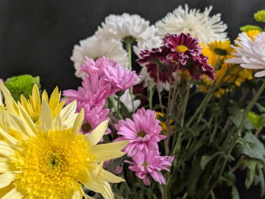 Koyu arkaplanda güzel bir buket çiçek, yakın çekim manzarası.             