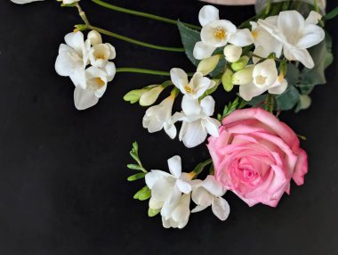 gül ve frezya çiçekleri siyah arkaplanda 