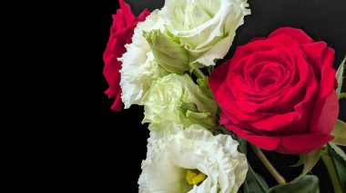 Kırmızı ve beyaz çiçekler vazoda bir araya getirildi.