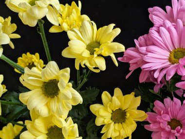 Sarı ve pembe çiçekler güzel bir şekilde bir araya getirilmiş.