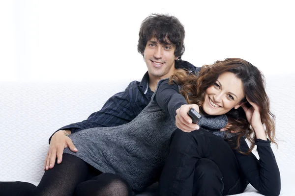 Happy couple lying down in bedroom watching television together — Stock Photo, Image