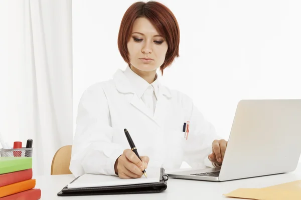 Ärztin sitzt hinter ihrem Schreibtisch — Stockfoto