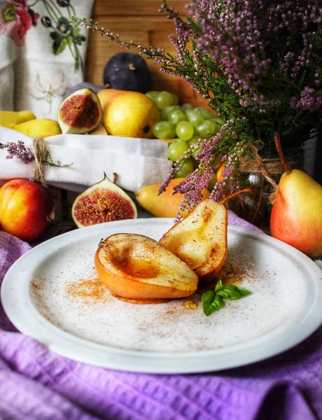 Fruit nature morte poires cuites au sirop sur une assiette blanche avec une feuille de menthe — Photo