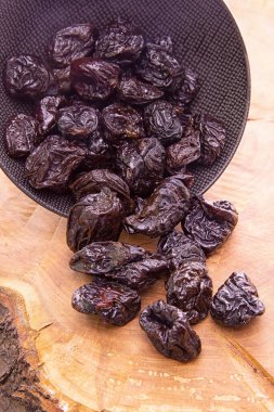 Kuru erik, koyu bir bardaktan bir oduna dökülüyor.