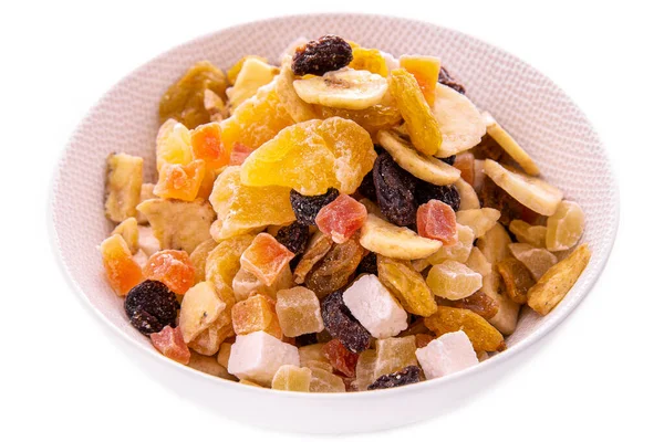 En blandning av hackade torkade frukter och bär, nötter i en vit skål på en vit bakgrund. Enskilda föremål och produkter. Stockfoto