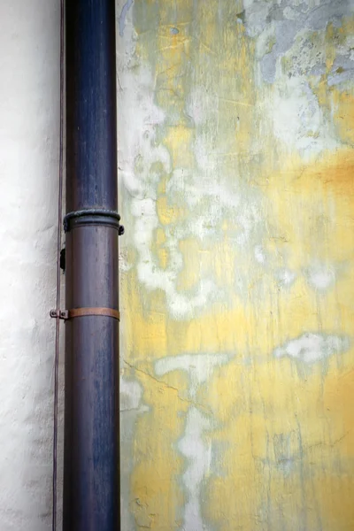 Желоб дождя на выцветшей стене — стоковое фото
