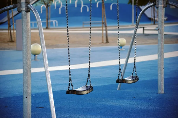 Parque infantil moderno com baloiços — Fotografia de Stock