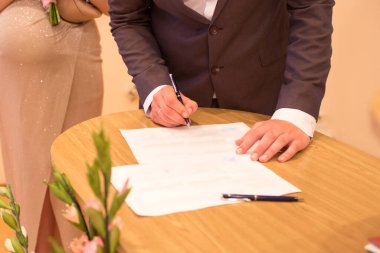 Damat evlilik belgesini imzalar.