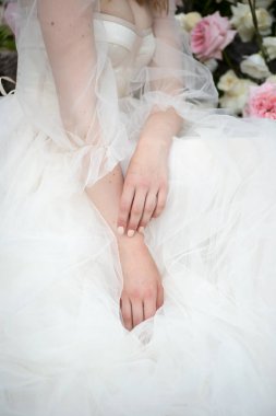 Gelin elleri elbisenin üzerinde katlanmış olarak oturur.