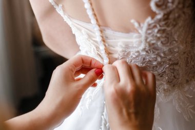 Nedime gelinliği ilikliyor.