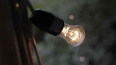 Kamera, yanan bir lambadan içeri ve dışarı zumluyor.