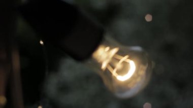 Kamera, yanan bir lambadan içeri ve dışarı zumluyor.