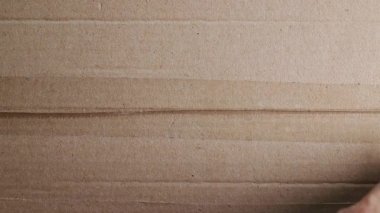 Şeffaf bandı çıkartan kahverengi bir karton kutunun paketini açmak