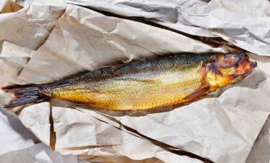 Kahverengi kağıda tütsülenmiş ringa balığı.