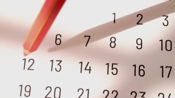 赤い鉛筆でカレンダー上の12 14の十字記号番号でマーク — ストック動画