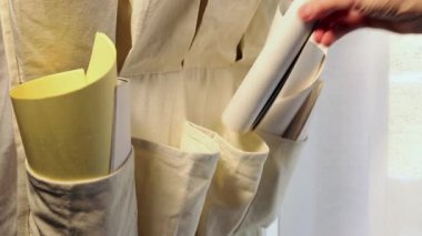 Kadın eli, sarılı çalışma kağıtlarını sıraya koyar, sarı ve beyaz kağıtlar. 