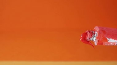 Turuncu suluboya tüpü turuncu arkaplana bastırılıyor, fırçayla rengi kaldır 