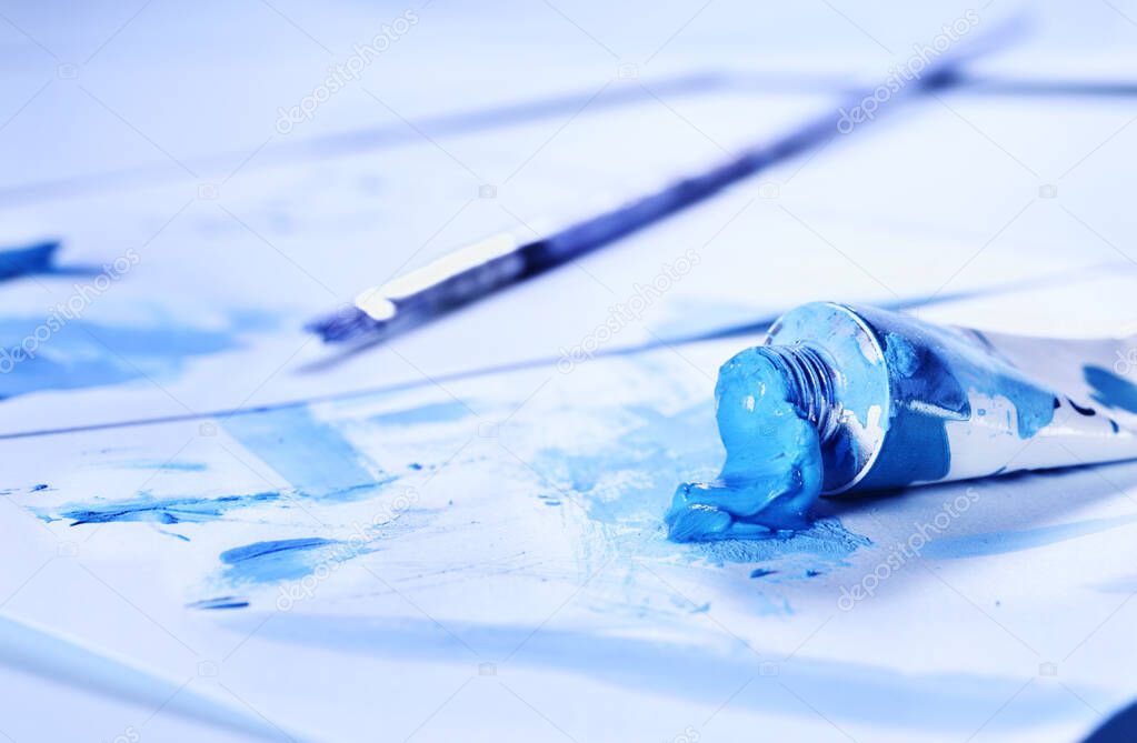 Blue tube of paint and paint brush