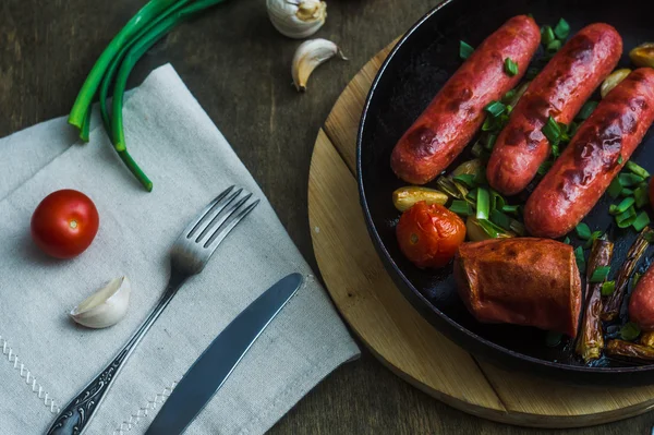 Grilled sausages with vegetables in a frying pan — Stock Photo, Image