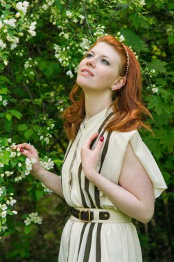 elma bahçesi içinde güzel kızıl saçlı kız yürüyor