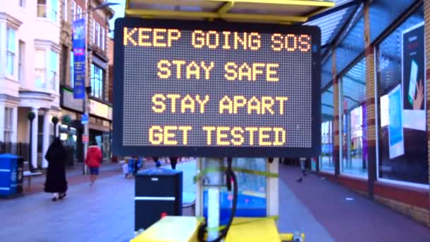 Получить тестирование, остаться безопасным цифрового экрана объявление на высокой улице в Великобритании — стоковое видео