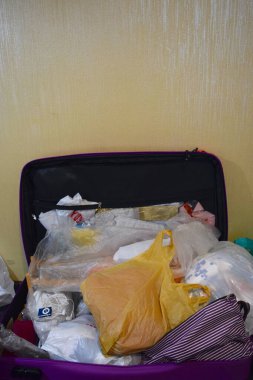 Tecrübesiz yolculara ait dağınık bavullu mor bavulu aç.