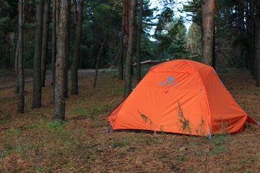 Shulgovka, Ukrayna - 17 Ekim 2020: Kozalaklı ormanlarda Marmot şirketinin üç kişilik turuncu çadırı.
