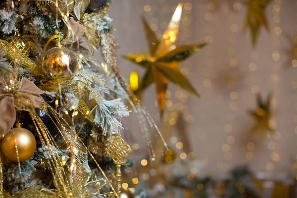 贺卡的金色圣诞背景 圣诞树 装饰着金球 星星装饰着花环 圣诞快乐 新年快乐 图库图片