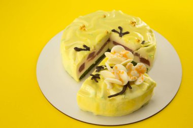 İnce dilimli limon renkli diyet kek. Dondurma sufle ve çilekli kek. Beyaz çikolata orkidesi yaprakları ve sarı arka planda altın inciler.