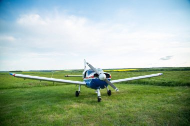 Walking small propeller plane on a green field