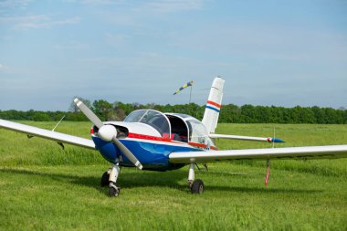 Walking small propeller plane on a green field