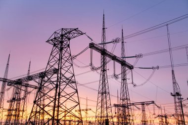 Pembe bir günbatımının arka planına karşı ekstra yüksek voltajlı bir akım..