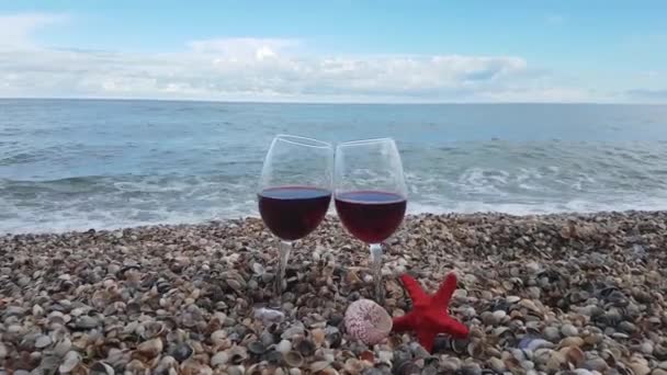 적포도주를 유리잔 바닷가에 조가비 배경에 하늘을 배경으로 — 비디오