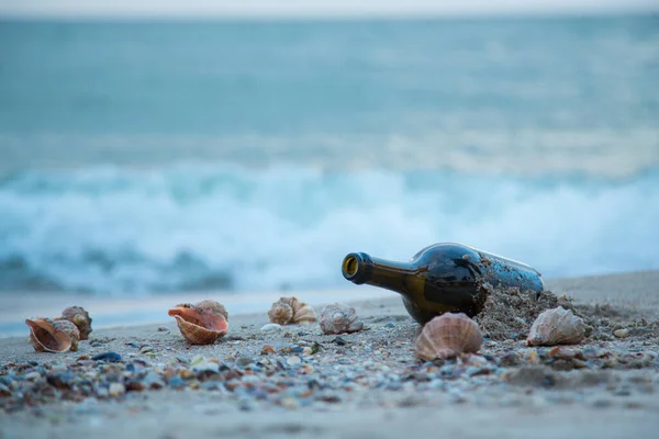 Пляшка Лежить Березі Моря Тлі Рапанових Снарядів Хвиль — стокове фото