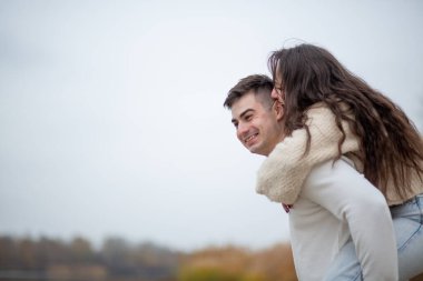 Nehir kıyısında mutlu genç bir çift yürüyor.