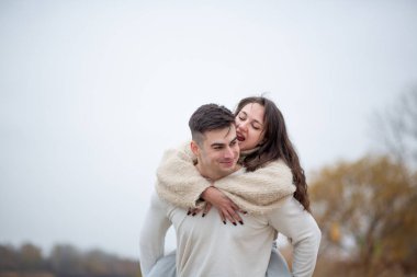 Nehir kıyısında mutlu genç bir çift yürüyor.