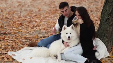 Genç bir çift ve Samoyed köpeği pikniğe gittiler.