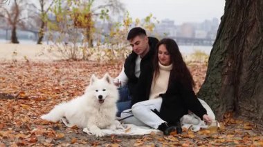 Genç bir çift ve Samoyed köpeği pikniğe gittiler.